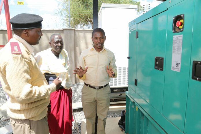 Safaricom Head of Regional Sales and Operations - Nairobi East, George Mbyuki explains how the base station works to Torosoi Area Chief Paul Keloi and Torosoi Village elder Peter Lakara - Bizna Safaricom Head of Regional Sales and Operations - Nairobi East, George Mbyuki explains how the base station works to Torosoi Area Chief Paul Keloi and Torosoi Village elder Peter Lakara - Bizna
