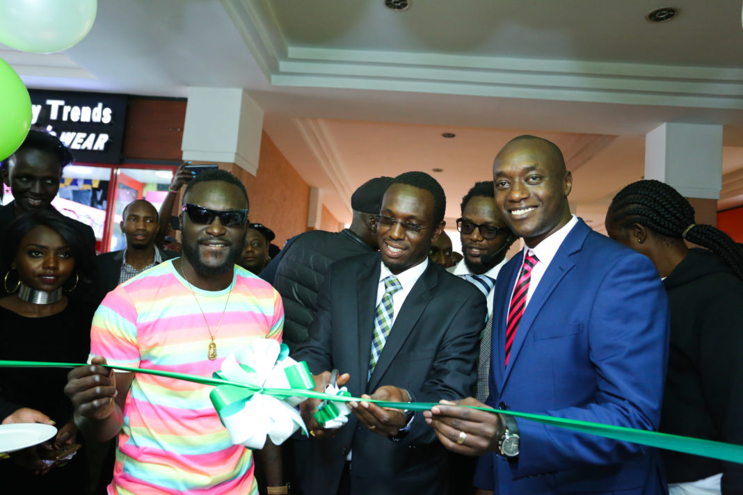 Safaricom, Head of Department Rift Region, Victror Ngumo (right), Nakuru County Executive Member for Trade, Dr. Peter Ketyenya (centre) and artist Naiboi, cut the ribbon to officially open the New Safaricom Westside shop in Nakuru town - Bizna
