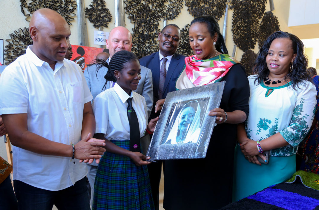 Prudence Atieno a student at Mpesa Academy presents a portrait to Education CS Amina Mohamed during the facility tour and launch of great debaters contest Season 8. Looking on is Thika Town MP Patrick Wainaina (left) and CE education Thika County Julia Wanjiru. - Bizna