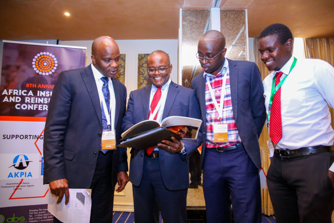 Liberty Life Managing Director, Abel Munda (second left), interacts with, Turnkey Africa Limited- CEO, Kizito Makatiani (left) and Forensics PWC- Senior Manager, John Kamau (second right) and CWD Limited- Managing Director, Edwin Magalasie peruse through a document during the 08th Annual Africa Insurance & Reinsurance Conference held in Nairobi.