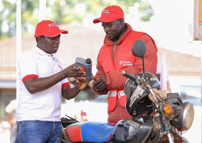 Erick Kiplagat, Lubricant Reseller Manager, Total Kenya (left) takes through Andrew Olang a boda boda operator the benefits of the newly launched Total Hi–Perf oil made for motorcycles in Kakamega.