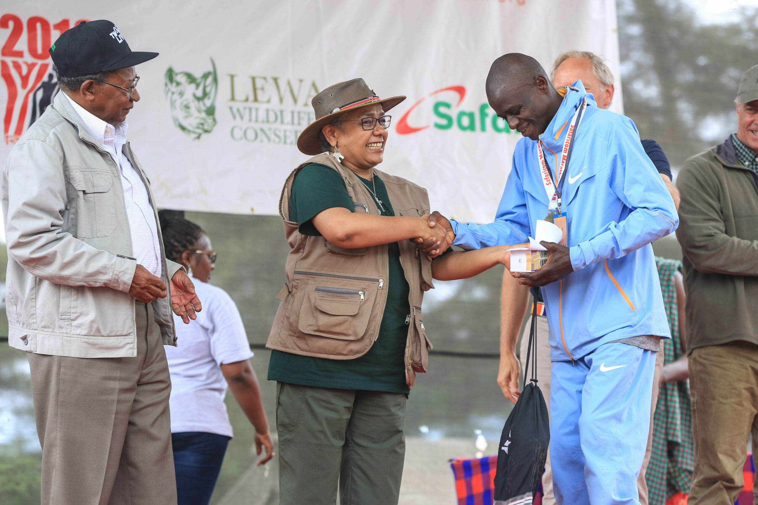 First Lady, Margaret Kenyatta presents the winners award in men category Safaricom Marathon in Lewa to Philomena Boru. Looking on is Safaricom Chairman Nicholas Nganga.