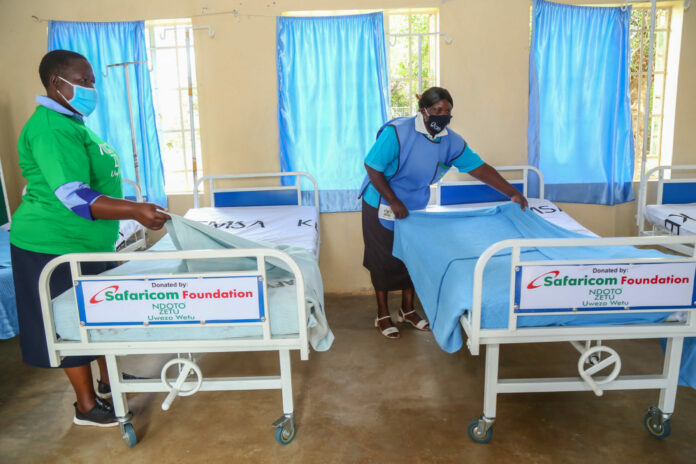 Celestine Atieno(right) and Lydia Obado (left) nurses at Andigo Opanga heath Center spread and arrange the new maternal bed donated by Safaricom Foundation through Ndoto Zetu.The handover was officially done at Andigo Opanga health Centre, Kisumu county - Bizna