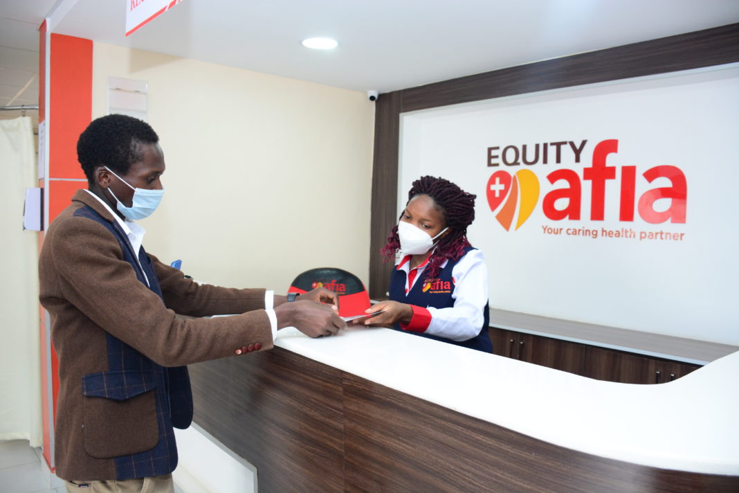 Equity Afia Front Office Representative, Celestine Aengwo (behind the desk) attends to a client at the newly opened Kitengela Medical Centre. Equity Afia has opened three new medical centres in Kitengela, Ngong and along the Eastern Bypass bringing its footprint to 23 medical centres nationally - Bizna Kenya