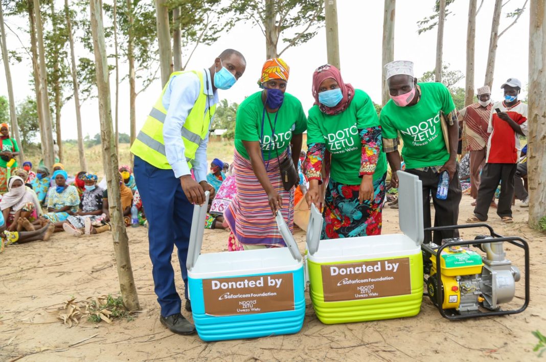 Safaricom, Tsavo Area Sales Manager, Lawrence Mutua, hands over a water pump and fish coolers to Tsamvulani Mwache Fishermen and Traders Association in Kwale County - Bizna