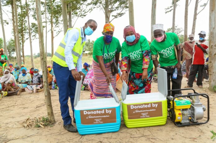 Safaricom, Tsavo Area Sales Manager, Lawrence Mutua, hands over a water pump and fish coolers to Tsamvulani Mwache Fishermen and Traders Association in Kwale County - Bizna