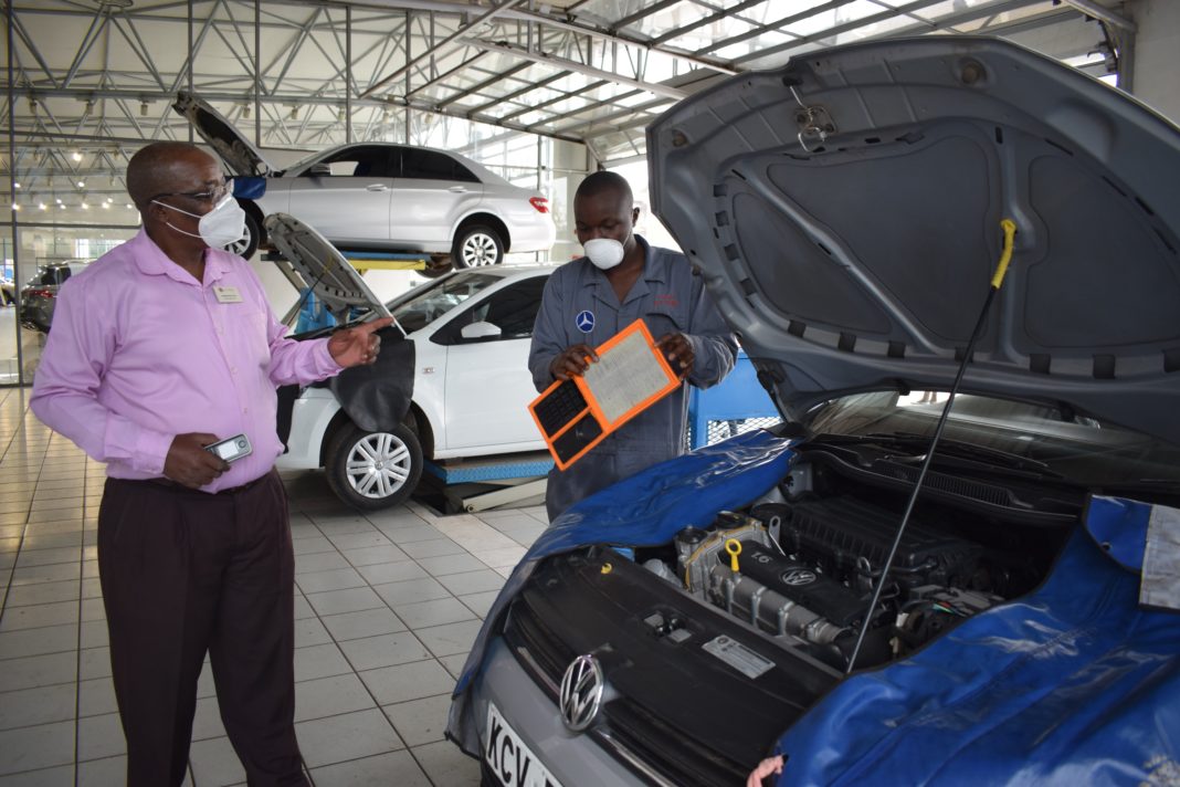DT Dobie Express Service Centre: Titus Koech, (right) DT Dobie Technician shows Bartholomew Osoro (left), the Express department Service Advisor an air filter which needs replacement on a Volkswagen at the Company’s Express Service Centre located off Enterprise road - Bizna Kenya