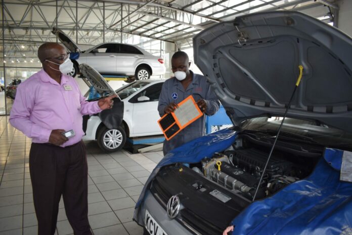 DT Dobie Express Service Centre: Titus Koech, (right) DT Dobie Technician shows Bartholomew Osoro (left), the Express department Service Advisor an air filter which needs replacement on a Volkswagen at the Company’s Express Service Centre located off Enterprise road - Bizna Kenya