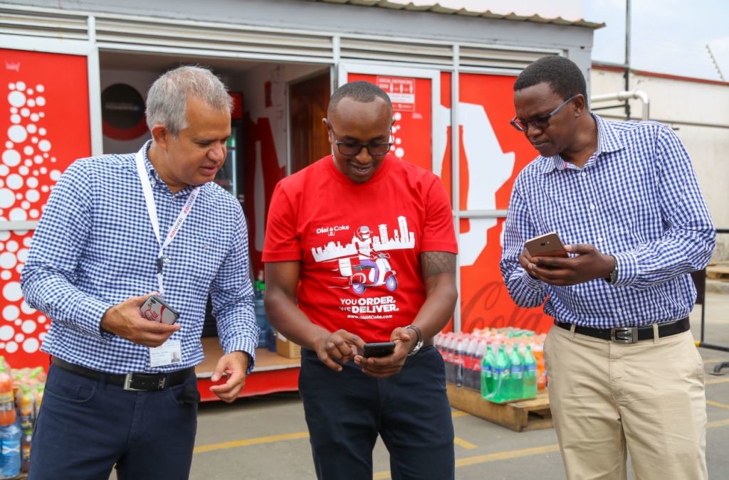 Franchise Director, Kenya and Tanzania, Oliver Soto (left), Coca-Cola Marketing Manager- Kenya, Evanson Ndung’u (middle) and Sales and Marketing Director - CCBA, Josphat Mwangi (right) attempt to make an order via DialACoke during the launch event at Nairobi bottlers offices in Embakasi - Bizna Kenya