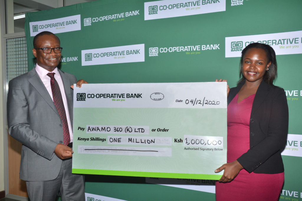 Vincent Marangu - Director, Co-operatives Banking at Co-op Bank hands the Sh 1 million prize money dummy cheque to Customer Success Officer at Awamo 360 Kenya Ltd Ms Tracy Itindi, being one of the winners of Akili Kali Innovators Challenge