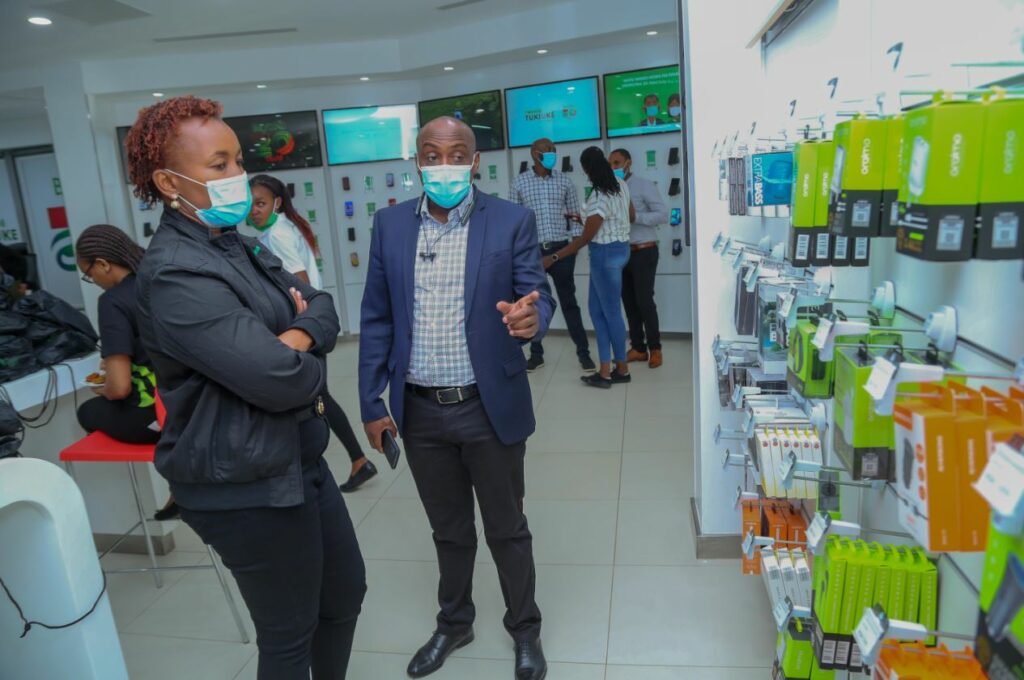 Safaricom Chief Customer Officer Sylvia Mulinge being shown the new phone accessories by Simon Kariithi - Oraimo managing director distributor to Safaricom during the launch of Safaricom newly refurbished Safaricom shop in Moi avenue, Nairobi.