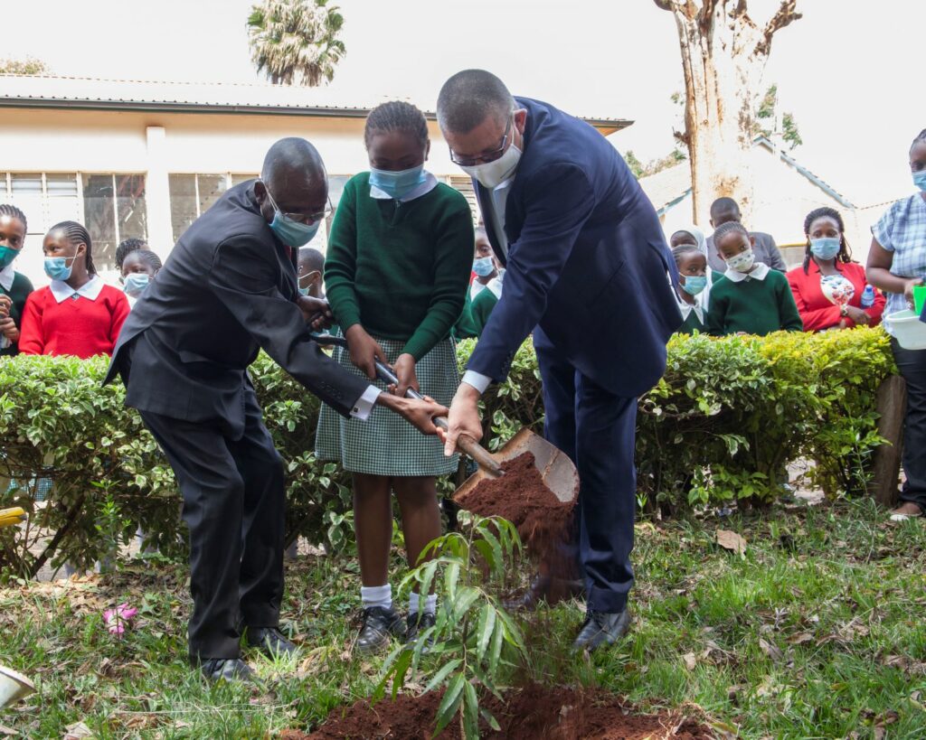(R-L) Mabati Rolling Mills CEO Andrew Heycott, Michelle Wanjiku a student at Westland Primary School and the school's Head Teacher Fredrick Otieno plant a tree during the handover ceremony of the RainGain Water Harvesting System by Mabati Rolling Mills - Bizna Kenya