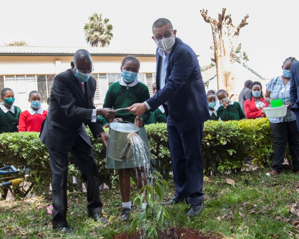 (R-L) Mabati Rolling Mills CEO Andrew Heycott, Michelle Wanjiku a student at Westlands Primary School and the school's head teacher Fredrick Otieno water a tree during the handover ceremony of the RainGain donation by Mabati Rolling Mills - Bizna Kenya