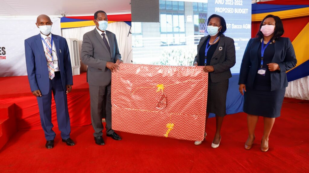 Ali Noor Ismail, Principal Secretary, State Department for Co-operatives (third right) receives a token of appreciation from Director Imelda Bore during the 47th delegates Annual General Meeting at the society’s property situated in Mwiki off Eastern Bypass, Nairobi. Looking on is National Chairperson Mrs Rebecca Miano (right) and National Vice Chairman Engineer Albert Mugo (left) - Bizna Kenya