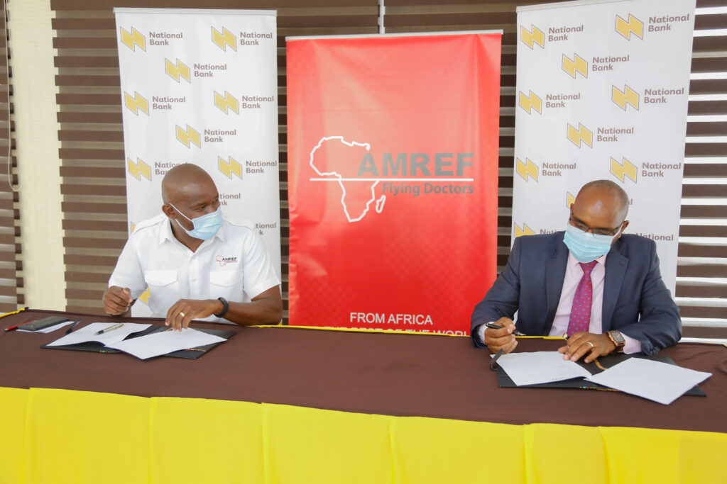 The Managing Director of National Bank of Kenya, Paul Russo (right) and Amref Flying Doctors CEO, Stephen Gitau (left) signing an MOU between NBK and Amref Flying Doctors to provide air evacuation and ground ambulance services for its customers, in case of a medical emergency - Bizna Kenya