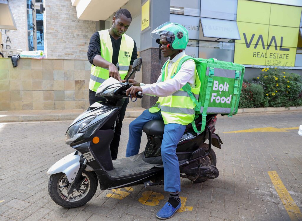 Edga Kipngetich, Bolt Food Country Manager (Left) with Daniel Karim Bolt Food courier go through the features of an electric bike during Bolt Ebike launch at their offices in Nairobi - Bizna Kenya