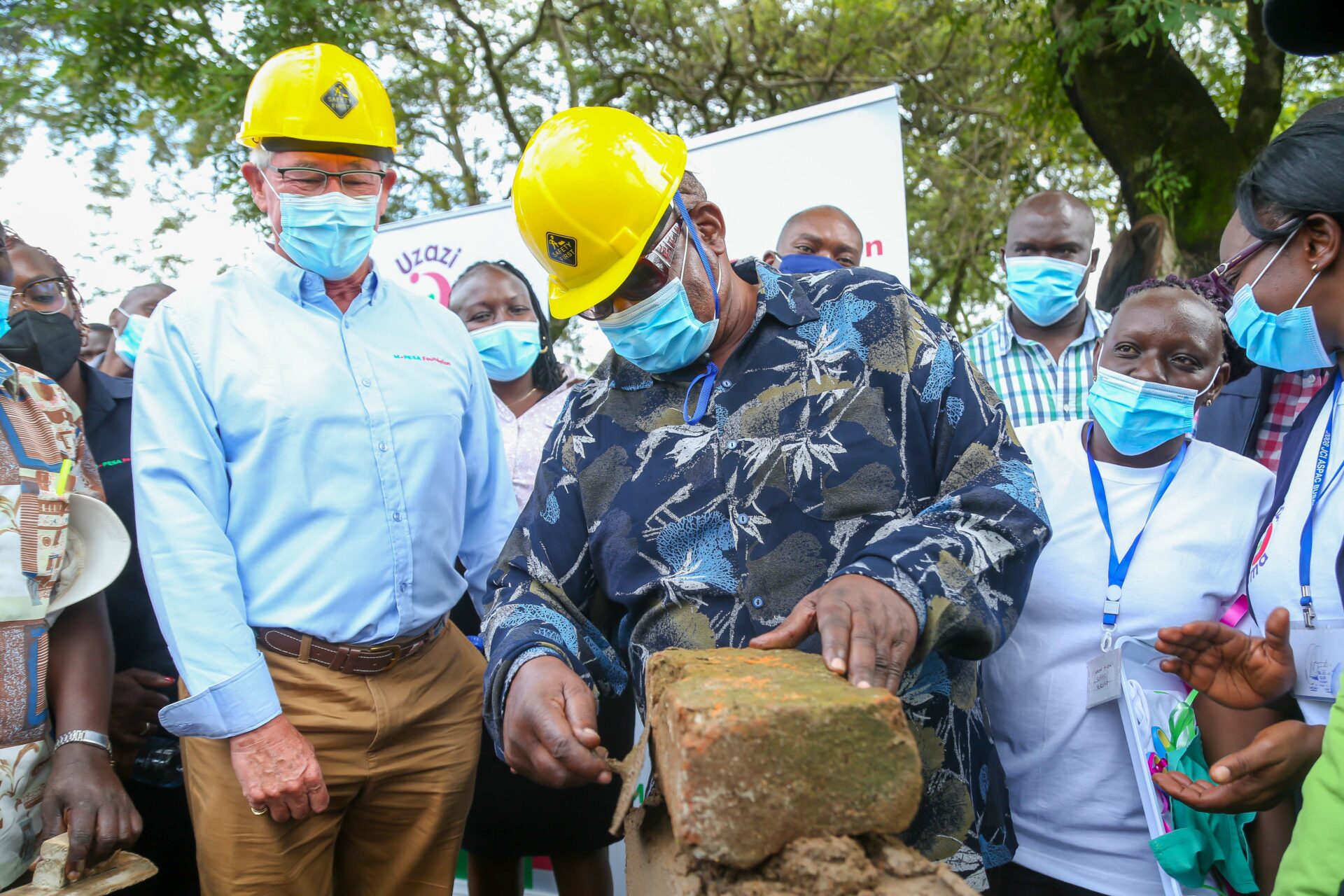 Governor, County Government of Homabay H.E. Hon. Cyprian Awiti places a brick as MPESA Foundation Mr. Les Baillie(left)Chief Executive Officer looks through during the groundbreaking of Maternity Unit to Ndhiwa Sub County Hospital through the Uzazi Salama Project. The event was held at Ndhiwa Sub County Hospital Homabay County - Bizna Kenya