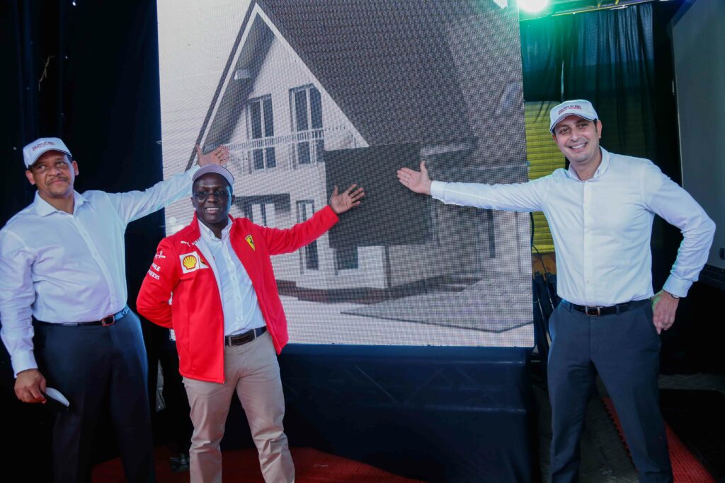 Vivo Energy Executive President East and South Regions, Hans Paulsen (left) ) Vivo Energy Kenya Managing Director, Peter Murugi (center) and Vivo Energy Kenya Retail Manager, Saadallah Adel (right) pose for a photo infront of a dummy house that was shown on screen during the Jaza Raha na Shell Shinda Nyumba during its official launch - Bizna Kenya