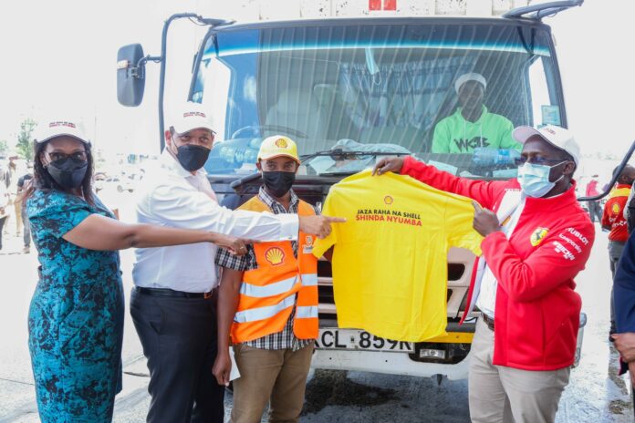 Vivo Energy Kenya Managing Director, Peter Murugi (right) handing over a branded t-shairt to truck owner, Josephat Waruru (second right) pointing at the t-shirt are Vivo Energy Executive President East and South Regions, Hans Paulsen (second left) and Shell Kamaki’s Retailer, Lucy Mwiti (left) - Bizna Kenya