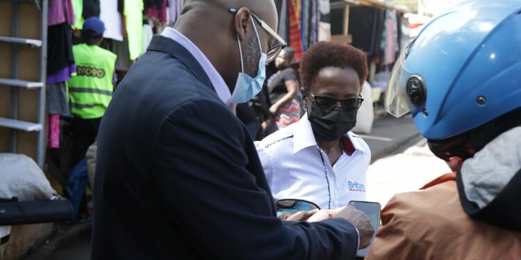 Telkoms Director for Marketing, Eric Achola and Britam’s Partnerships and Digital Director, Evah Kimani take a boda boda rider through the insurance product