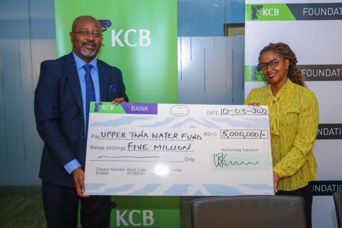 KCB, Group director Marketing Corporate Affairs and Citizenship, Rosaline Gichuru(Right) and CEO, Water Fund Upper Tana Nairobi, Emmanuel Rurema(Left) pose with a dummy cheque during the KCB Foundation, MoU signing with the Upper Tana Nairobi Water Organization at Kencom offices - Bizna Kenya