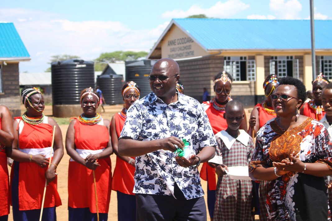 Labour Cabinet Secretary Simon Chelugui speaks at Salabani Primary School during the commissioning of new classes and other structures constructed by ChildFund Kenya at the cost of Ksh30 million. Looking on is ChildFund Kenya Country Director Alice Anukur (right) - Bizna Kenya