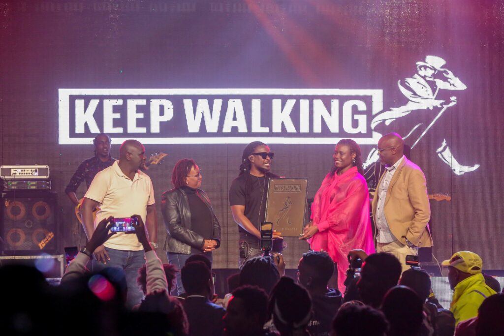 Nyamari Ongengú AKA Nyashinski is presented with a plaque by EABL Head of Spirits Flavia Othim as he's unveiled as Johnnie Walker's brand ambassador - Bizna Kenya