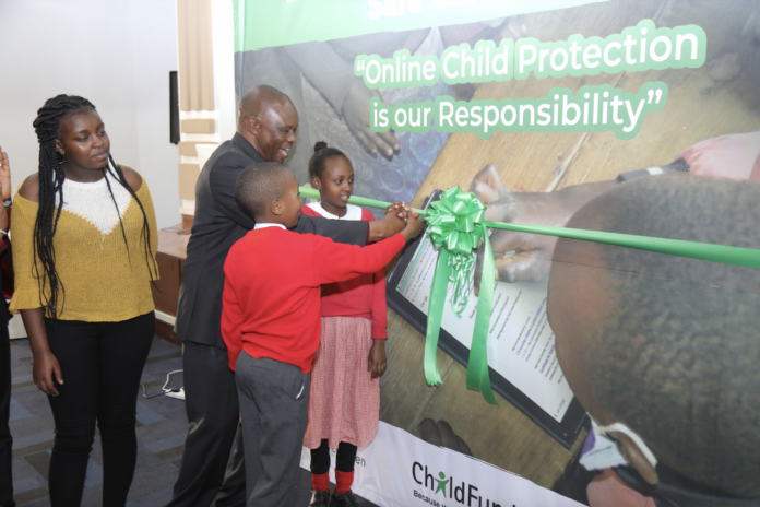 Charles Ondogo, the director of Children's Services in the state department for social protection, leads pupils of Mukuru Primary School, Nairobi, in the official launch of the Safe Community Linkages for Internet Child Safety (Safe CLICS) programme - Bizna Kenya