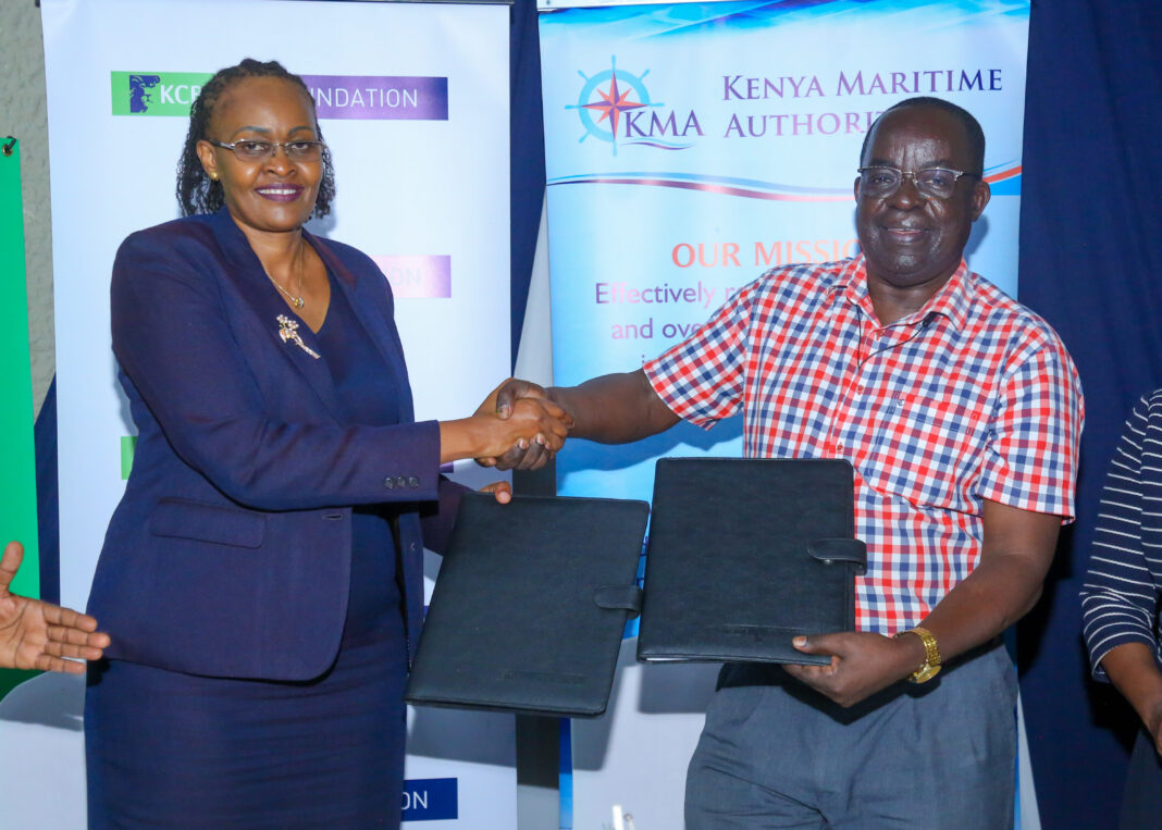 KCB Director Retail Mrs. Annastacia Kimtai and  Ag. Director General Kenya Maritime Authority John Omingo exchange their signed MoU and shake hands to signify their partnership and agreement to support the entry of more youths into seafarer jobs - Bizna Kenya
