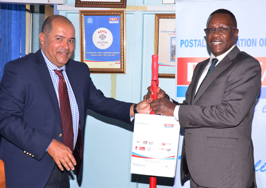 Mr Peter Kanaiya (left) the Postal Corporation of Kenya Board Chairman hands over a gift pack to Mr Eliud Owalo, the Cabinet Secretary for Information, Communication and Digital Economy when the minister visited the corporation’s offices during a familiarization tour - Bizna Kenya