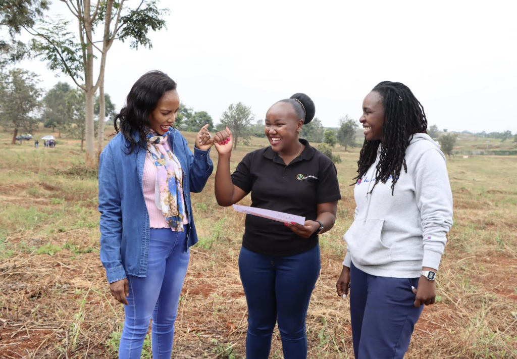 L-R, Safaricom Investment Co-operative Board Secretary Judy Rono  and CEO Sarah Wahogo share a land masterplan with Lorella Jowi, a customer during the open day of Marina Gardnes- a 100 acre project in Kiambu county - Bizna Kenya (Publisher)