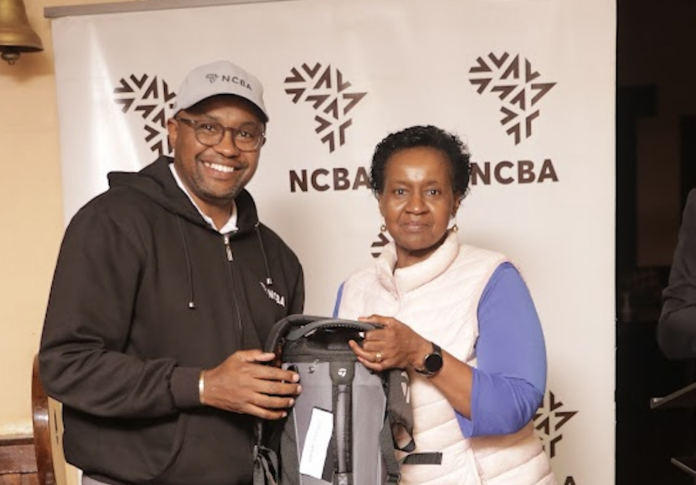 Faith Githaiga, the overall winner of the NCBA sponsored mug golf tournament receives a gift from NCBA Group Director, Retail Banking, Tirus Mwithiga - Bizna Kenya (Picture Courtesy)