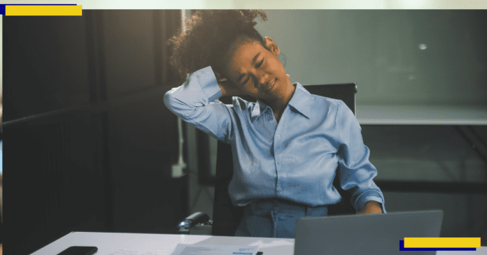 A woman working hard in the office having aches and pains.