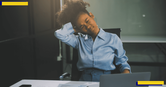 A woman working hard in the office having aches and pains.